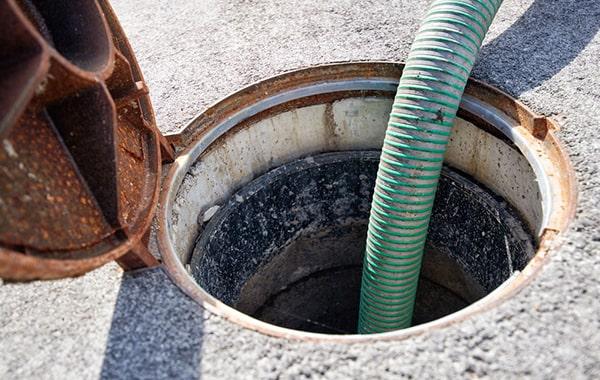 An opened under-sink grease trap with a thick layer of grease and food solids before cleaning in San Francisco, CA